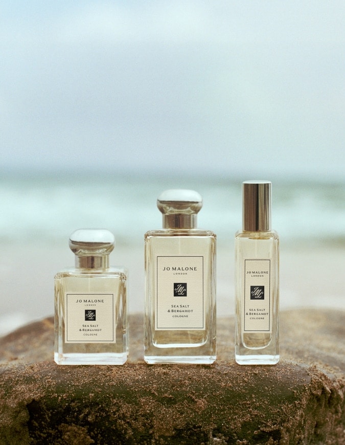 Jo Malone London Sea Salt & Bergamot colognes in three sizes displayed on rock by the sea.